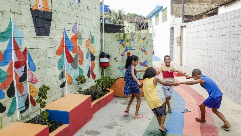 Quatro crianças brincam de roda em rua transformada pelo Mais Vida nos Morros